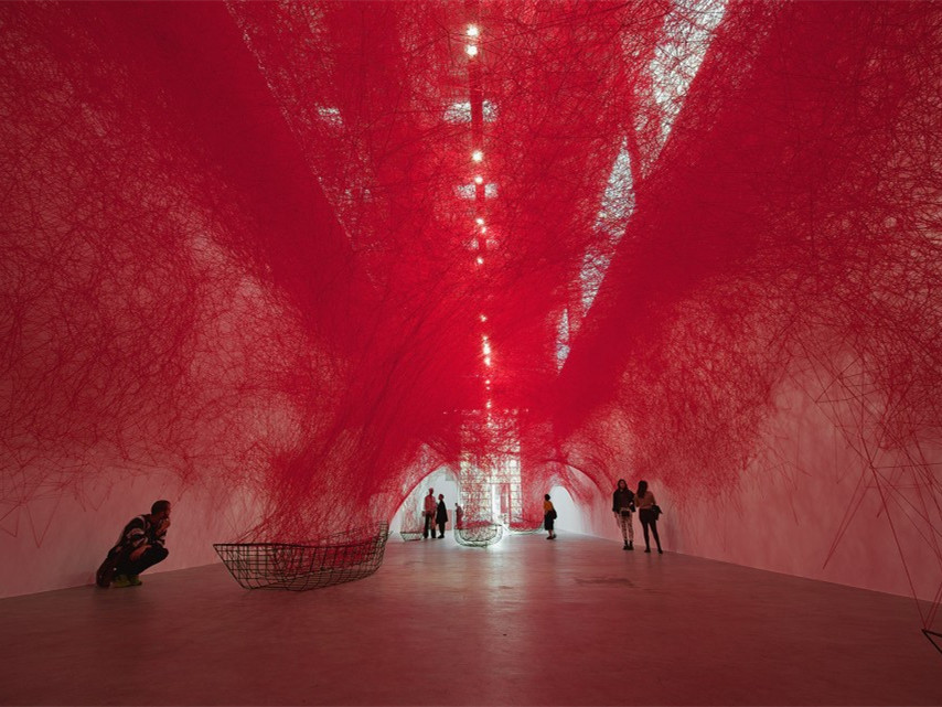 红色纱线编织网组成的艺术装置：前路未知的旅程